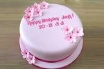 Write a greeting on the pink birthday cake